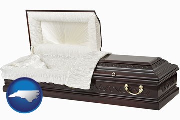 an open funeral casket - with North Carolina icon
